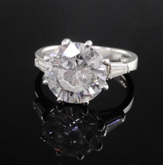 An attractive modern platinum and single stone diamond ring with trapeze cut diamond set shoulders, size K.